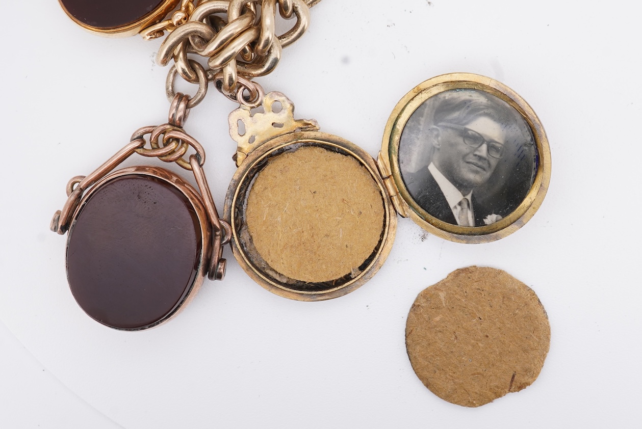 A 1970's 9ct gold curb link charm bracelet, with 9ct gold heart shaped clasp, hung with seven assorted gold or gilt metal mounted charms including six chalcedony set fob seals, gross weight 73 grams.